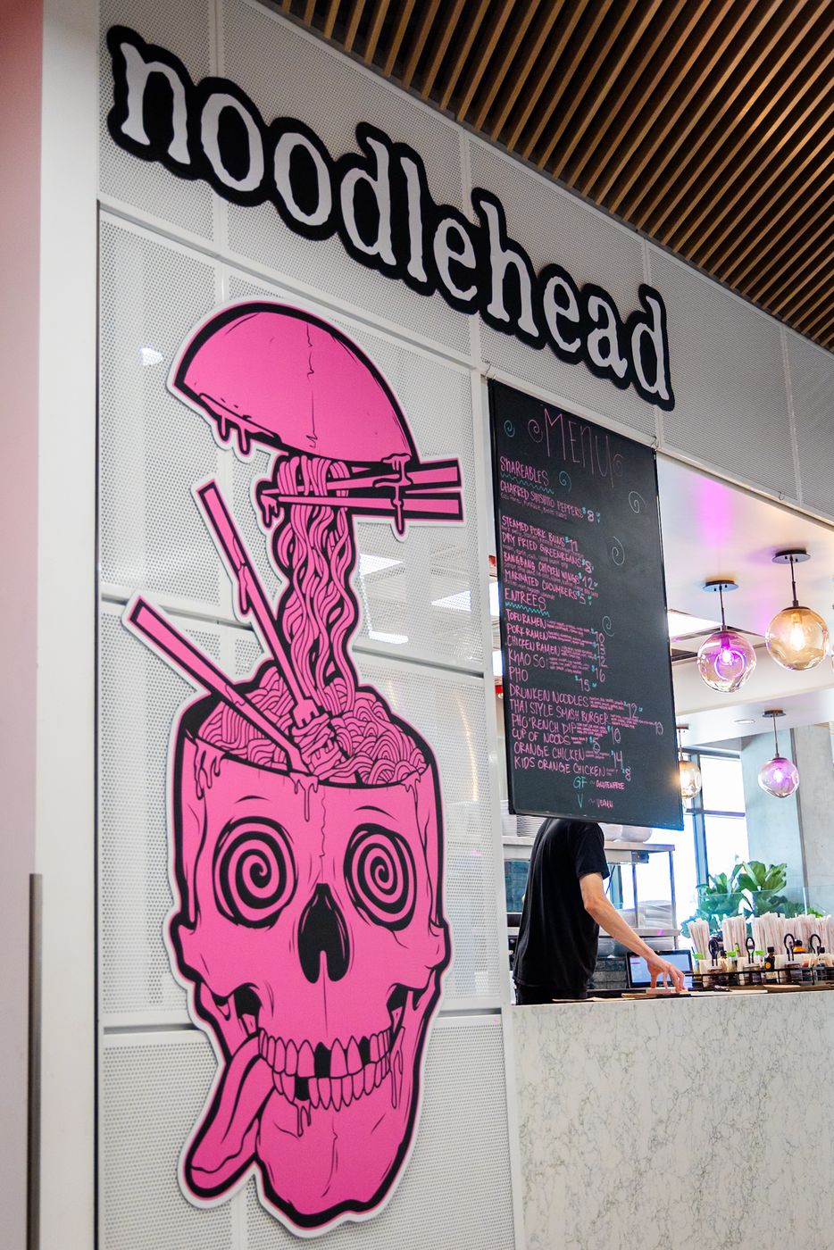 The Noodlehead counter at Millcreek Common, with the pink skull on the wall