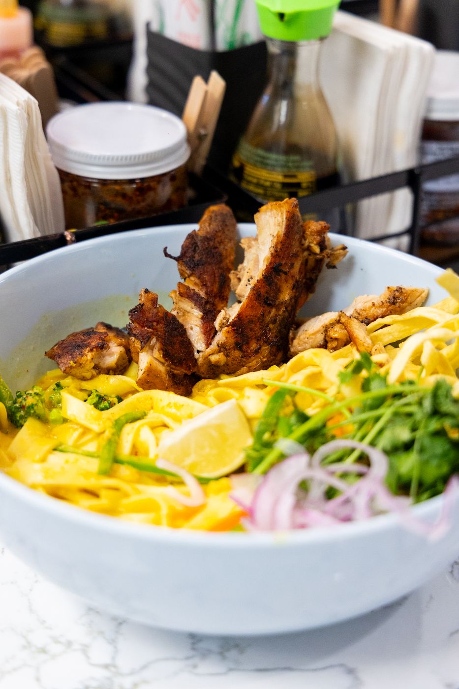 Khao soi: curry broth, egg noodles, roasted chicken thigh, crispy noodles, lime and red onion