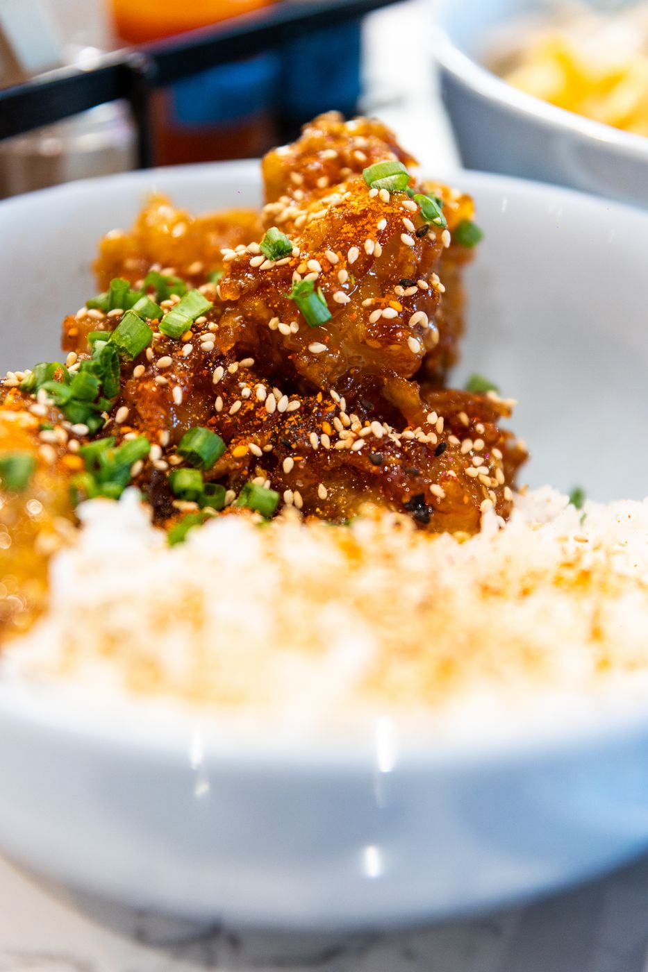 Orange chicken with sesame and scallion over white rice